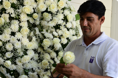 Colaborado montando uma coroa de flores com cuidado