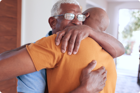 Homem mais velho abraçando homem mais jovem